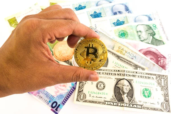 Adam beyaz arka plan üzerinde izole çoklu Döviz banknotların üzerinde elinde Bitcoin