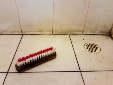 Eski kirli tuvalet kat, beyaz karo zemin üzerinde fırça yıkama,