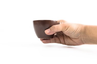 Adamın elini beyaz arka plan üzerinde kase seramik izole kahverengi seramik bardağı götürüyor