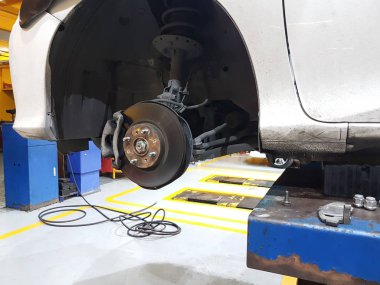 Beyaz araba mavi otomatik Asansör ile gezici onarıyor.