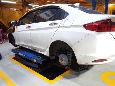 Beyaz araba mavi otomatik Asansör ile gezici onarıyor.