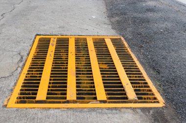 Metal ızgara kapağı kaba Asfalt yol yüzeyi ile sarı renkte drenaj