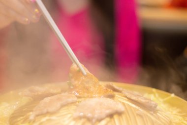 Bir dilim domuz eti, kadının Han 'daki çubuk tarafından topluyordu.