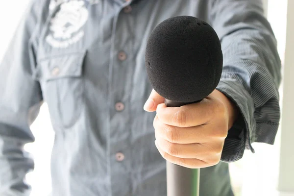 Black microphone in a hand of man