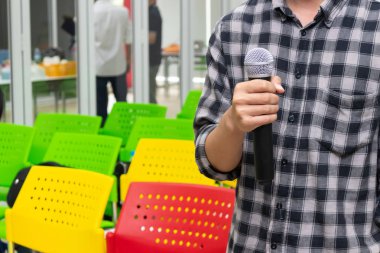 Odada sunum yapan adamın elinde mikrofon,