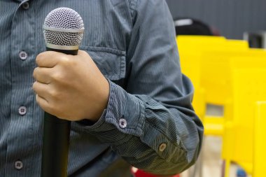 Odada sunum yapan adamın elinde mikrofon,