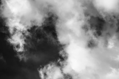 Beyaz bulutların üzerinde karanlık bir gökyüzü, tek renkli