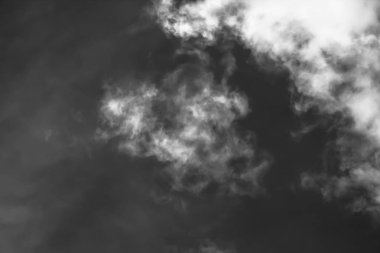 Beyaz bulutların üzerinde karanlık bir gökyüzü, tek renkli