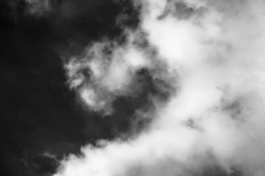 Beyaz bulutların üzerinde karanlık bir gökyüzü, tek renkli