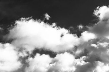 Beyaz bulutların üzerinde karanlık bir gökyüzü, tek renkli