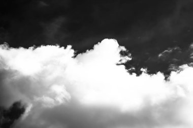 Beyaz bulutların üzerinde karanlık bir gökyüzü, tek renkli