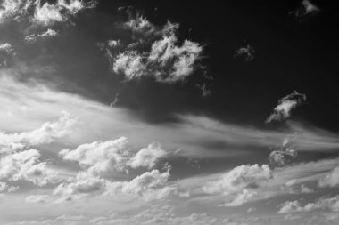 Beyaz bulutların üzerinde karanlık bir gökyüzü, tek renkli
