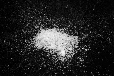 siyah bir arka plan üzerinde beyaz kristal toz. şeker tozu