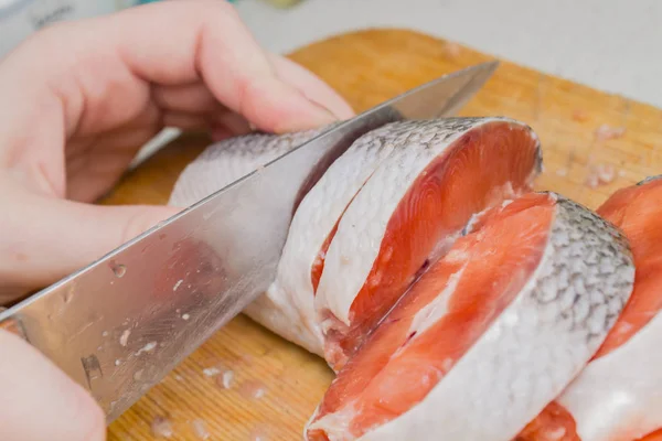 Vrouwelijke Hand Snijdt Rode Vis — Stockfoto