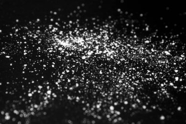  siyah bir arka plan üzerinde beyaz kristal toz. şeker tozu
