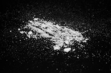  siyah bir arka plan üzerinde beyaz kristal toz. şeker tozu