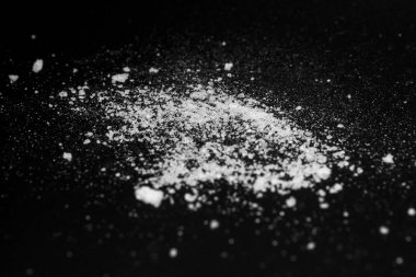  siyah bir arka plan üzerinde beyaz kristal toz. şeker tozu