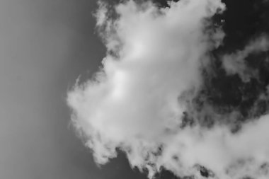 karanlık gökyüzüne karşı beyaz bulutlar. Monokrom