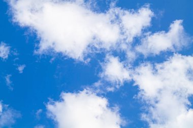 Mavi gökyüzüne karşı beyaz bulutlar.