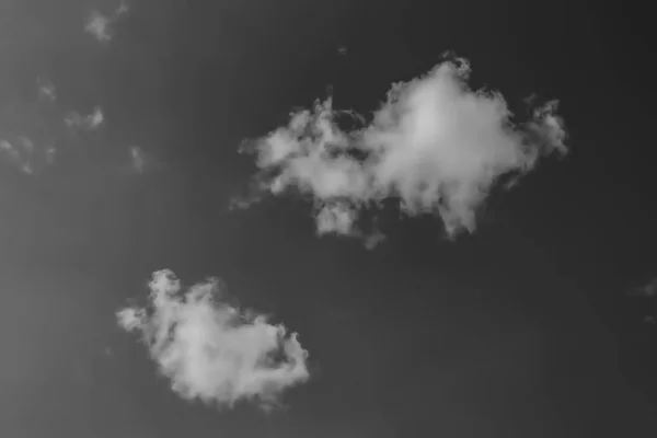 Witte wolken tegen de donkere hemel. Monochroom — Stockfoto