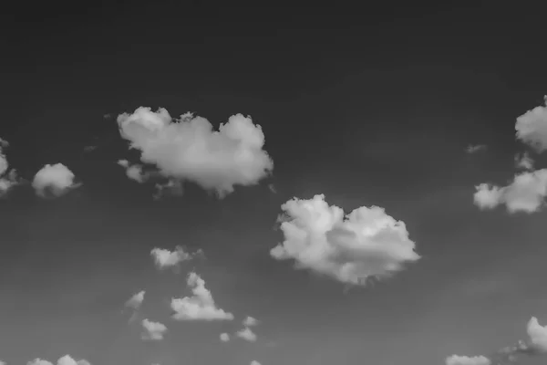 Witte wolken tegen de donkere hemel. Monochroom — Stockfoto