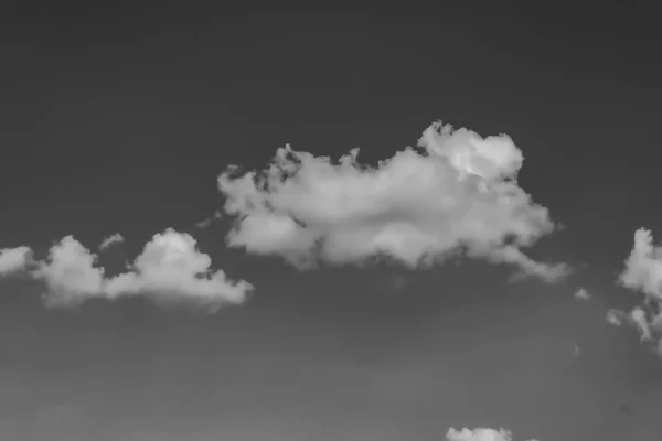 Witte wolken tegen de donkere hemel. Monochroom — Stockfoto