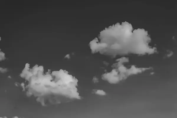 Nuvens brancas contra o céu escuro. monocromático — Fotografia de Stock