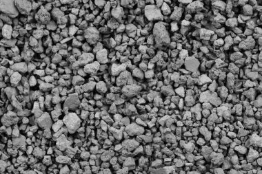 Gri küçük kayaların zemin dokusu. Siyah küçük yol taşı arka planı. Taş çakıl taşları, dikişsiz doku. Ezilmiş granit çakılların koyu arkaplanı, yakın plan. yığılan kil