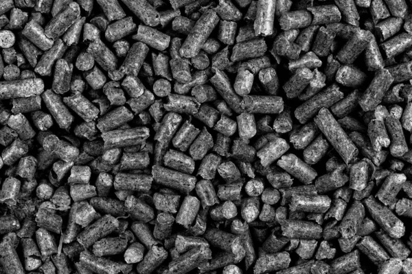 White and black wood pellets texture background. natural pile of wood pellets. organic biofuels. Alternative biofuel from sawdust. The cat litter. Close up on a pile of compressed wood pellets. grey mulch in the garden over. top wiew