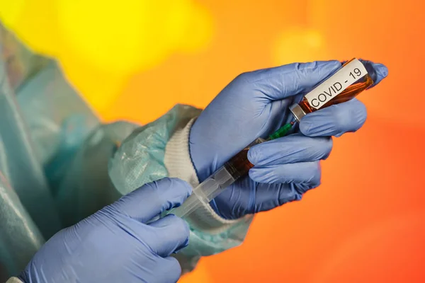 stock image A blue-gloved medical worker draws an ampoule into a syringe. Medical vaccination against coronavirus flu concept. injection bottle for medical glass vials. COVID pandemic