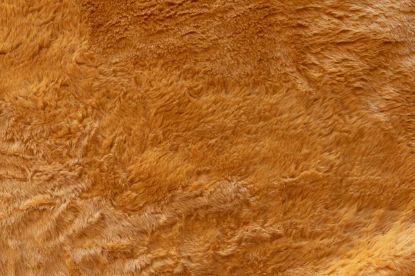 Brown real wool with a dark top texture background, orange natural wool,  fluffy fur texture for designers, close-up  wool rug