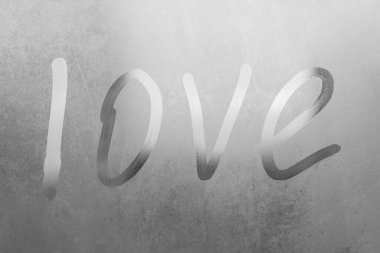 Terli bardaktaki yazıt aşkı. Karanlık arka planda sisli cam bir pencereye çizilmiş aşk. Sisli camda yalnızlığın ve aşkın sembolü.