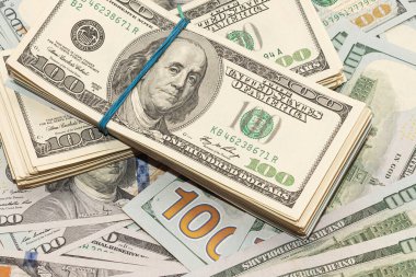 Ahşap masa arkaplan dokusunda yüzlerce dolarlık banknotlar. Bir tomar para ofis masasına saçıldı. zenginlik ve gelir kavramı