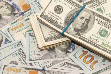 Ahşap masa arkaplan dokusunda yüzlerce dolarlık banknotlar. Bir tomar para ofis masasına saçıldı. zenginlik ve gelir kavramı