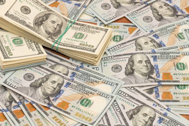 Ahşap masa arkaplan dokusunda yüzlerce dolarlık banknotlar. Bir tomar para ofis masasına saçıldı. zenginlik ve gelir kavramı