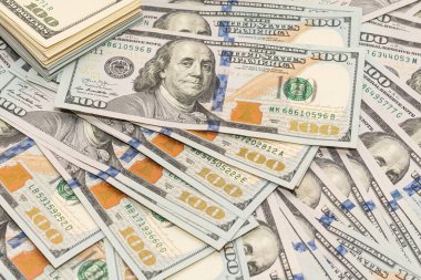 Ahşap masa arkaplan dokusunda yüzlerce dolarlık banknotlar. Bir tomar para ofis masasına saçıldı. zenginlik ve gelir kavramı