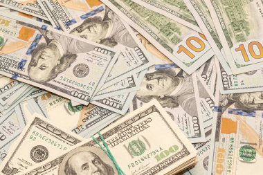 Ahşap masa arkaplan dokusunda yüzlerce dolarlık banknotlar. Bir tomar para ofis masasına saçıldı. zenginlik ve gelir kavramı