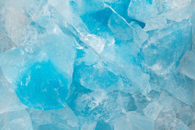 Ezilmiş mavi buz parçaları arka plan dokusunu çatlatıyor. Yakın çekim donmuş su