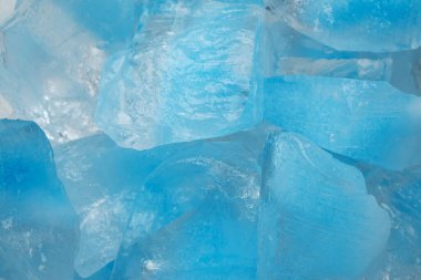 Ezilmiş mavi buz parçaları arka plan dokusunu çatlatıyor. Yakın çekim donmuş su