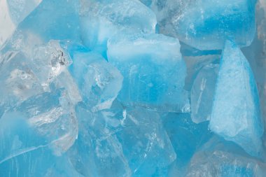 Ezilmiş mavi buz parçaları arka plan dokusunu çatlatıyor. Yakın çekim donmuş su