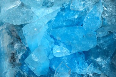Ezilmiş mavi buz parçaları arka plan dokusunu çatlatıyor. Yakın çekim donmuş su