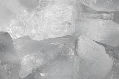 Ezilmiş beyaz buz parçaları arka plan dokusunu çatlatıyor. Yakın çekim donmuş su