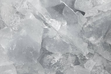 Ezilmiş beyaz buz parçaları arka plan dokusunu çatlatıyor. Yakın çekim donmuş su