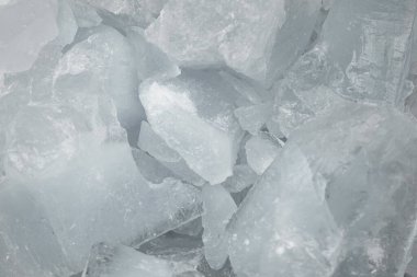Ezilmiş beyaz buz parçaları arka plan dokusunu çatlatıyor. Yakın çekim donmuş su