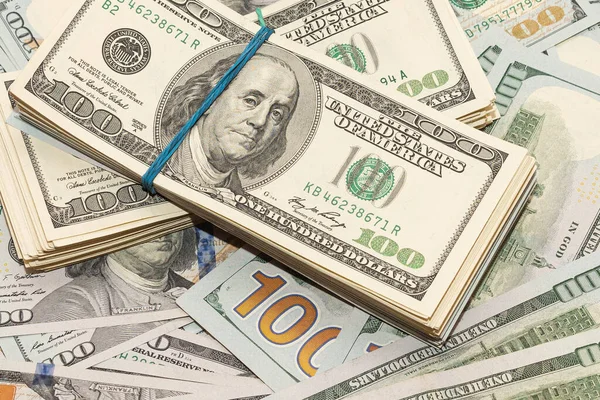 Ahşap masa arkaplan dokusunda yüzlerce dolarlık banknotlar. Bir tomar para ofis masasına saçıldı. zenginlik ve gelir kavramı