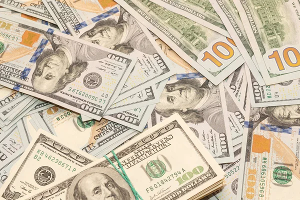 Ahşap masa arkaplan dokusunda yüzlerce dolarlık banknotlar. Bir tomar para ofis masasına saçıldı. zenginlik ve gelir kavramı