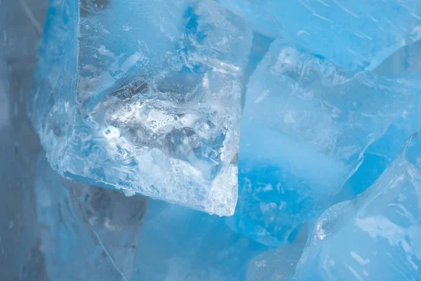 Pieces of crushed blue ice glass cracks background texture. close-up frozen water