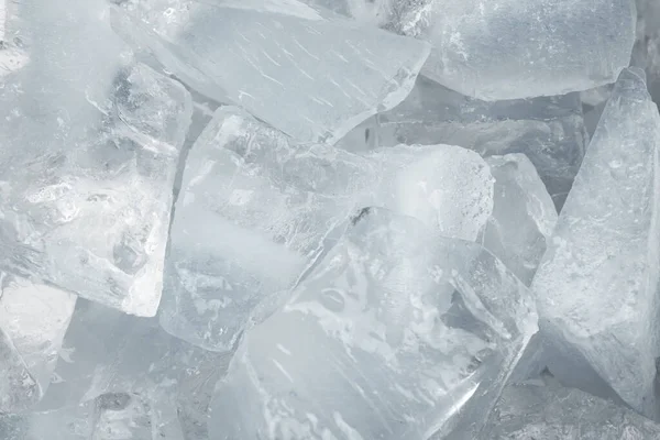 Ezilmiş beyaz buz parçaları arka plan dokusunu çatlatıyor. Yakın çekim donmuş su