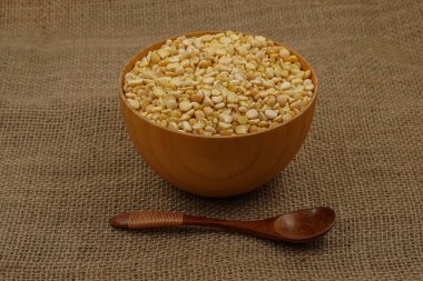 Çuval bezi dokusuna tahta kaşık ve kaşık ile işlenmemiş sarı tabak.