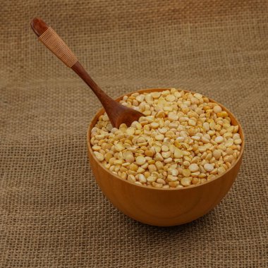 Çuval bezi dokusuna tahta kaşık ve kaşık ile işlenmemiş sarı tabak.